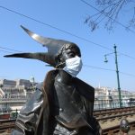 Close photo of the Little Princess statue wearing a mask during times of Covid-19 in Budapest