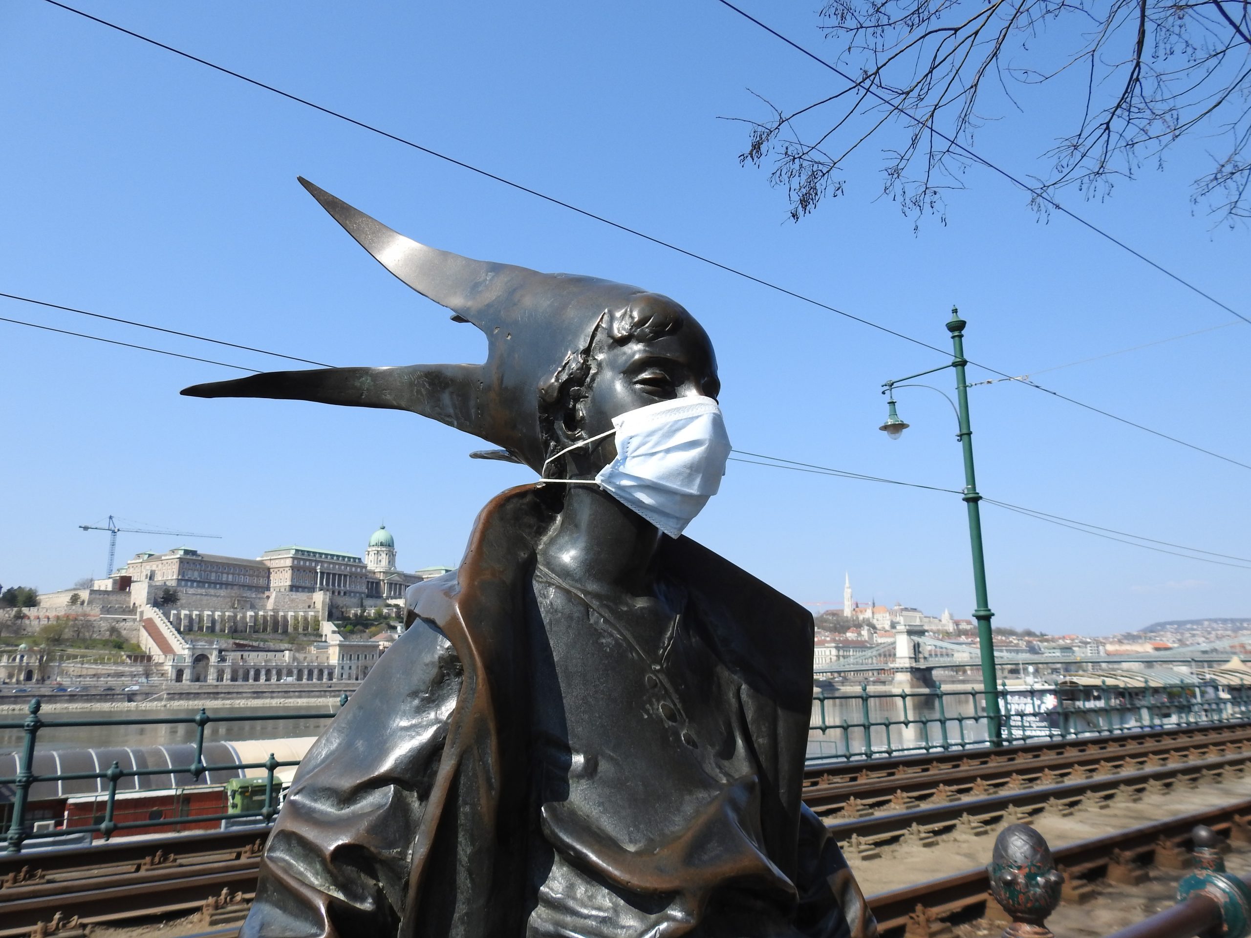 Close photo of the Little Princess statue wearing a mask during times of Covid-19 in Budapest