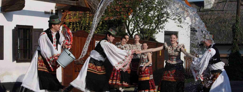 Hungarian youngsters on the countryside performing an Easter tradition, boys pouring water on girls from a bucket