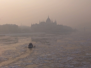 Foggy photo taken during wintertime of the icy river Danube and the Hungarian Parliament building