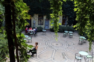 Picture of the garden bar part of Építészpince with a lot of green plants and a mosaic floor