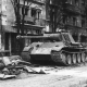 Black and white picture of apartment buildings and a a tank on the streets of the center of Budapest