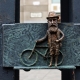 Caption of one of the mini statues of Hungarian sculptor Mihaly Kolodko depicting Theodore Herzl with his bike