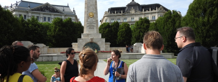 A group with our guide in blue uniform on the Liberty square, in front of the Soviet war memorial of Budapest