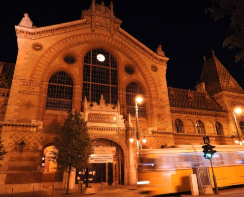 Photo the Central market hall of Budapest at night with an old yellow tram passing by (Evening tour finishes here)