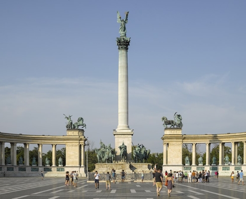 This is the Heroes' square in Budapest on a beautiful sunny day with travelers having a walk on it