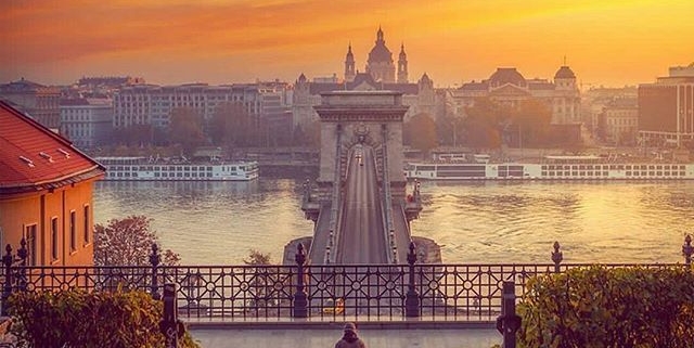 A sunset it Budapest with the iconic Chain bridge and a passenger
