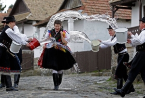 Boys watering a girl dressed in traditional folk clothes at Easter in Hungary